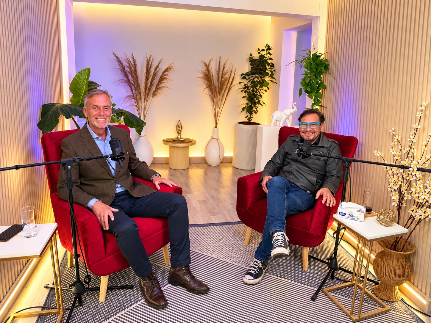 Dos invitados conversan desde sillones rojos en el estudio de podcast de Santiago